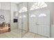 Welcoming front foyer featuring tile flooring, a mirrored accent wall and a full view of the front door at 9234 Duffer Ct, Hudson, FL 34667