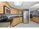 Well-lit kitchen with light wood cabinets, stainless steel appliances, and a stylish blue patterned floor at 9234 Duffer Ct, Hudson, FL 34667