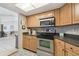 Cozy kitchen with light wood cabinetry, stainless steel oven, and a patterned floor leading to other rooms at 9234 Duffer Ct, Hudson, FL 34667