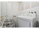 Laundry room with white washer and dryer and open laundry baskets at 9234 Duffer Ct, Hudson, FL 34667