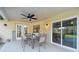 Outdoor patio with seating and dining area, connecting to the interior with sliding glass doors and a view of the yard at 9234 Duffer Ct, Hudson, FL 34667