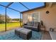 Comfortable screened patio with outdoor seating and a view of the lush backyard at 9234 Duffer Ct, Hudson, FL 34667