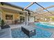 Covered patio featuring a dining table, seating area, and inviting in-ground pool for outdoor enjoyment at 9234 Duffer Ct, Hudson, FL 34667