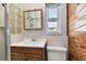 Bathroom with wooden vanity, toilet, and shower with glass block window at 969 Britton St, Largo, FL 33770