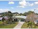 Charming single-story home featuring mature palm trees, a covered carport, and a well-manicured front yard at 969 Britton St, Largo, FL 33770