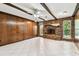 Spacious living room showcasing a brick fireplace, wood paneled walls, and tile flooring at 969 Britton St, Largo, FL 33770