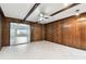 Living room featuring wood-paneled walls, tile flooring, and an open doorway at 969 Britton St, Largo, FL 33770