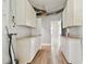 Utility room with laminate floors, white storage cabinets, and neutral walls at 969 Britton St, Largo, FL 33770