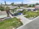 Aerial view of a blue single Gathering home with a brick driveway, lush landscaping, and palm trees at 114 12Th St, Belleair Beach, FL 33786