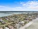 Expansive aerial shot of a residential neighborhood near the water, showcasing the community's layout under a partly cloudy sky at 114 12Th St, Belleair Beach, FL 33786