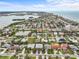 Scenic aerial perspective of a neighborhood with a tranquil pond, showcasing well-maintained homes and verdant landscapes at 114 12Th St, Belleair Beach, FL 33786