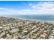 Aerial view of the desirable neighborhood offering a beautiful view of the beach, water, and blue skies at 114 12Th St, Belleair Beach, FL 33786