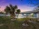 Landscaped backyard featuring a patio, palm tree, and tropical accents at 114 12Th St, Belleair Beach, FL 33786