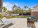 Private backyard patio featuring modern outdoor seating and lush tropical landscaping for a tranquil outdoor living space at 114 12Th St, Belleair Beach, FL 33786