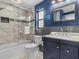 Modern bathroom showcasing blue accent wall, combined tub-shower and a vanity with a gray-tiled backsplash at 114 12Th St, Belleair Beach, FL 33786