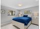 Bright bedroom featuring tiled floors, neutral wall paint, and a large bed with matching nightstands at 114 12Th St, Belleair Beach, FL 33786