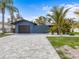 Beautiful exterior of a well maintained single Gathering home featuring a large brick driveway and a lush tropical landscape at 114 12Th St, Belleair Beach, FL 33786