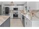 Well-lit kitchen with white cabinets, modern stainless steel appliances, and beautiful marble countertops at 114 12Th St, Belleair Beach, FL 33786