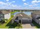 Aerial shot of a lovely home with a lake view, a manicured lawn, and a spacious driveway at 11717 Navajo Sandstone St, Riverview, FL 33579