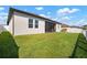 Backyard view showcasing the exterior wall and green lawn, offering a glimpse into outdoor living at 11717 Navajo Sandstone St, Riverview, FL 33579