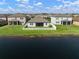 Backyard view with a screened-in porch, white fence, and lake views, showcasing outdoor living and privacy at 11717 Navajo Sandstone St, Riverview, FL 33579