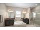 Well-lit bathroom featuring a soaking tub, granite countertops and a glass enclosed shower at 11717 Navajo Sandstone St, Riverview, FL 33579