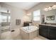 Elegant bathroom featuring a standalone soaking tub and double vanity sinks at 11717 Navajo Sandstone St, Riverview, FL 33579