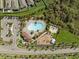 Aerial view of a community pool, clubhouse, playground, sports court, and parking area within neighborhood at 11717 Navajo Sandstone St, Riverview, FL 33579