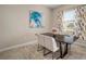 A formal dining table sits in front of a window with stylish curtains and an artful modern painting at 11717 Navajo Sandstone St, Riverview, FL 33579