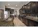 Kitchen featuring stainless steel appliances, dark cabinets, granite countertops, and a tile backsplash at 11717 Navajo Sandstone St, Riverview, FL 33579