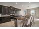 Kitchen with a large island featuring barstool seating, stainless steel appliances, and dark cabinetry at 11717 Navajo Sandstone St, Riverview, FL 33579