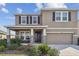 Two-story home with neutral colors, black shutters, stone accents, a covered porch and a two-car garage at 12326 Dora Trl, Parrish, FL 34219