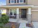 Charming front porch with stone accents, rocking chairs, and a welcoming entrance at 12326 Dora Trl, Parrish, FL 34219