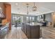 Kitchen island with stainless steel sink, wood cabinets and appliances plus view into the living room at 12326 Dora Trl, Parrish, FL 34219