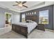 Bedroom featuring a tray ceiling, a large bed with two nightstands, and a door leading to the bathroom at 12326 Dora Trl, Parrish, FL 34219