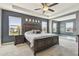 Bedroom featuring a tray ceiling, a large bed with two nightstands, and large windows at 12326 Dora Trl, Parrish, FL 34219