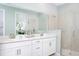 Bathroom with double sink vanity, large mirror, and glass-enclosed shower at 12363 Hearts Ease St, Venice, FL 34293