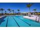 A long swimming pool with black lane lines surrounded by lounge chairs, palm trees, and yellow umbrellas at 12363 Hearts Ease St, Venice, FL 34293