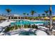 A stunning view of the community pool, sun loungers and palm trees under a blue sky at 12363 Hearts Ease St, Venice, FL 34293