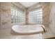 Luxurious soaking tub with natural lighting from decorative glass block window at 1370 Pinellas Rd, Belleair, FL 33756