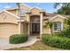 Elegant home featuring a grand double-door entrance, manicured landscaping, and a brick pathway at 1370 Pinellas Rd, Belleair, FL 33756