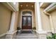 Elegant front entrance featuring double doors, decorative columns, and manicured landscaping at 1370 Pinellas Rd, Belleair, FL 33756