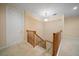 Upstairs hallway with wood railing and neutral carpet runner at 1370 Pinellas Rd, Belleair, FL 33756