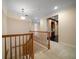 Upstairs hallway features wood railing and access to kitchen area at 1370 Pinellas Rd, Belleair, FL 33756