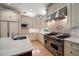 Kitchen showcasing stainless steel appliances, a gas range and custom tile backsplash at 1370 Pinellas Rd, Belleair, FL 33756