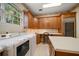 Well-lit laundry room with washer, dryer, sink, built-in cabinets, and wine cooler at 1370 Pinellas Rd, Belleair, FL 33756