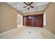 Spacious living room with coffered ceiling, ceiling fan, and custom built-in entertainment center at 1370 Pinellas Rd, Belleair, FL 33756