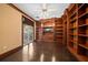 Living room with wood floors, custom bookshelves, and sliding glass door at 1370 Pinellas Rd, Belleair, FL 33756