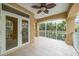 Spacious tiled balcony showcases a ceiling fan, and clear view of the lush, private yard with screened enclosure at 1370 Pinellas Rd, Belleair, FL 33756