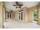 Large tile patio featuring fans and French doors with views of the backyard at 1370 Pinellas Rd, Belleair, FL 33756